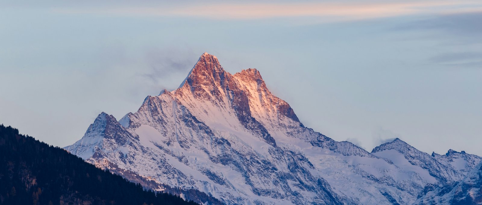 Alpenglühen an einem Schweizer Berggipfel bei Sonnenuntergang